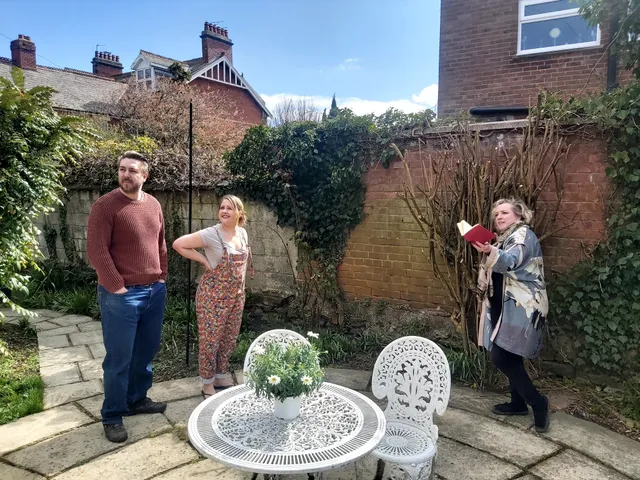 Charlotte instructs a young couple in their garden.