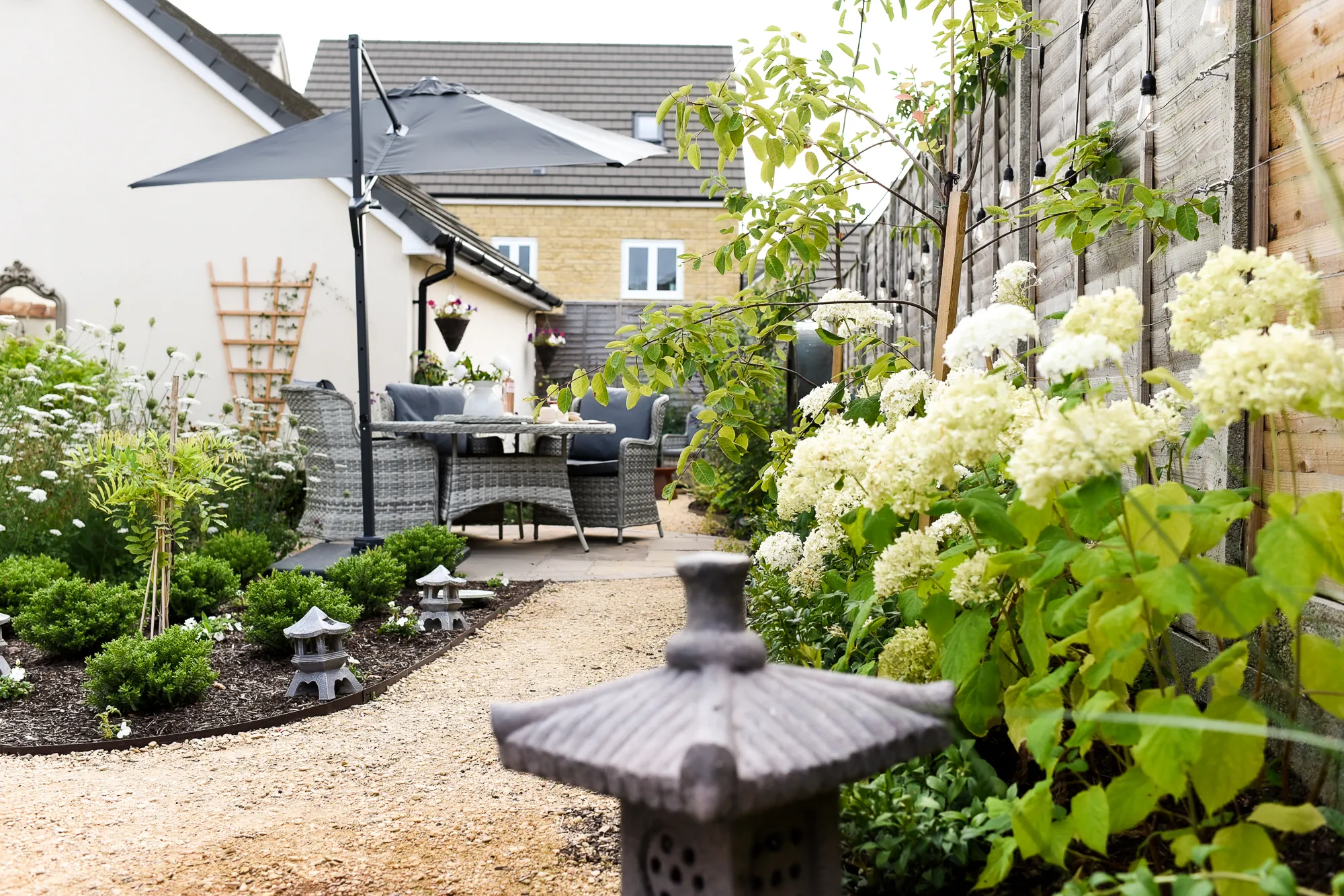 A view through a Japanese-themed area of the garden to a seating area in the distance. Photo by Victoria Tapper