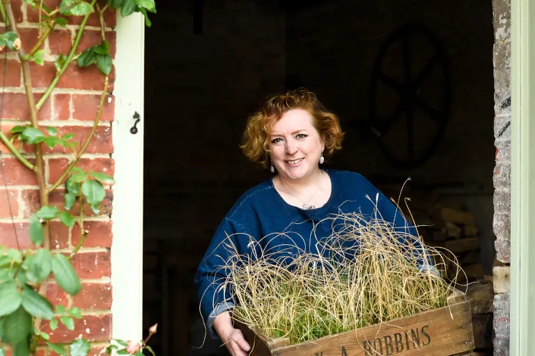 Charlotte carrying a tray of plants. Photo by Victoria Tapper